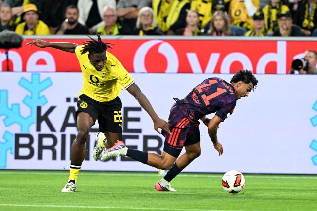 22 August 2026, Dortmund: Borussia Dortmund's Joane Gadou and Bayern Munich's Nathaniel Brown battle for the ball during the German Franz Beckenbauer Supercup soccer match between Borussia Dortmund and FC Bayern Munich at the Signal Iduna Park. Photo: Federico Gambarini/dpa - IMPORTANT NOTICE: Bundesliga and DFB regulations prohibit any use of photographs as image sequences and/or quasi-video.