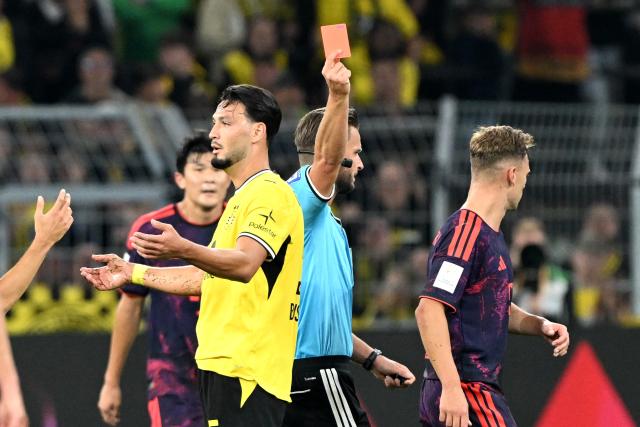 22 August 2026, Dortmund: Referee Daniel Schlager shows Borussia Dortmund's Ramy Bensebaini a red card during the German Franz Beckenbauer Supercup soccer match between Borussia Dortmund and FC Bayern Munich at the Signal Iduna Park. Photo: Federico Gambarini/dpa - IMPORTANT NOTICE: Bundesliga and DFB regulations prohibit any use of photographs as image sequences and/or quasi-video.