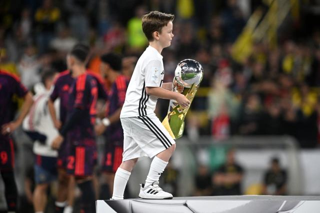 22 August 2026, Dortmund: A boy brings the trophy onto the podium after the German Franz Beckenbauer Supercup soccer match between Borussia Dortmund and FC Bayern Munich at the Signal Iduna Park. Photo: Bernd Thissen/dpa - IMPORTANT NOTICE: Bundesliga and DFB regulations prohibit any use of photographs as image sequences and/or quasi-video.