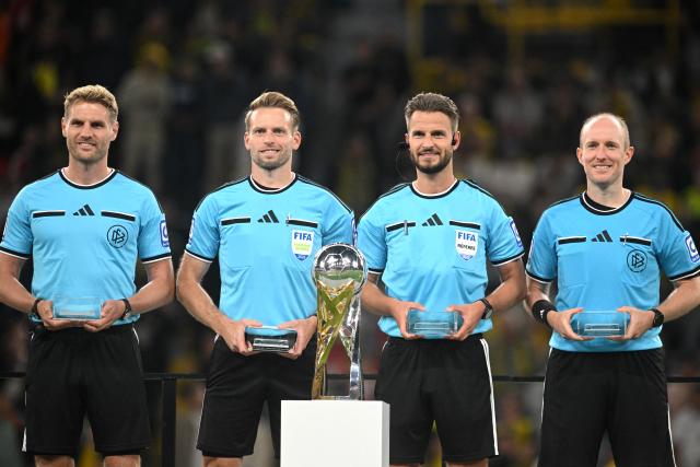 22 August 2026, Dortmund: Referee Daniel Schlager (2nd R) stands behind the trophy with his team after the German Franz Beckenbauer Supercup soccer match between Borussia Dortmund and FC Bayern Munich at the Signal Iduna Park. Photo: Bernd Thissen/dpa - IMPORTANT NOTICE: Bundesliga and DFB regulations prohibit any use of photographs as image sequences and/or quasi-video.