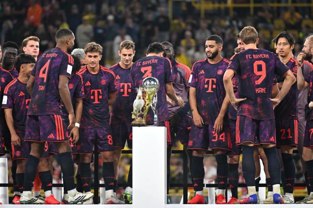22 August 2026, Dortmund: Bayern Munich players celebrate on the podium with the trophy after winning the German Franz Beckenbauer Supercup soccer match against Borussia Dortmund at the Signal Iduna Park. Photo: Bernd Thissen/dpa - IMPORTANT NOTICE: Bundesliga and DFB regulations prohibit any use of photographs as image sequences and/or quasi-video.