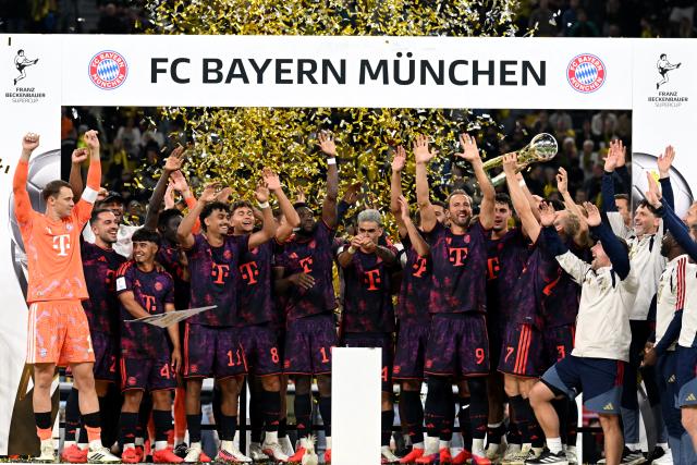 22 August 2026, Dortmund: Bayern Munich players celebrate with the trophy after winning the German Franz Beckenbauer Supercup soccer match against Borussia Dortmund at the Signal Iduna Park. Photo: Federico Gambarini/dpa - IMPORTANT NOTICE: Bundesliga and DFB regulations prohibit any use of photographs as image sequences and/or quasi-video.