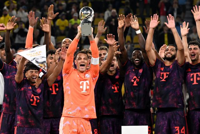 22 August 2026, Dortmund: Bayern Munich players celebrate with the trophy after winning the German Franz Beckenbauer Supercup soccer match against Borussia Dortmund at the Signal Iduna Park. Photo: Federico Gambarini/dpa - IMPORTANT NOTICE: Bundesliga and DFB regulations prohibit any use of photographs as image sequences and/or quasi-video.