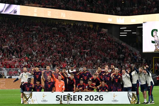 22 August 2026, Dortmund: Bayern Munich players celebrate with the trophy after winning the German Franz Beckenbauer Supercup soccer match against Borussia Dortmund at the Signal Iduna Park. Photo: Federico Gambarini/dpa - IMPORTANT NOTICE: Bundesliga and DFB regulations prohibit any use of photographs as image sequences and/or quasi-video.