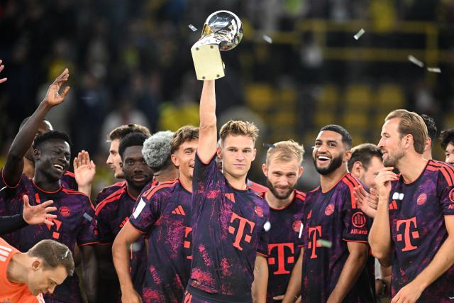 22 August 2026, Dortmund: Bayern Munich's Joshua Kimmich celebrates with the trophy after winning the German Franz Beckenbauer Supercup soccer match against Borussia Dortmund at the Signal Iduna Park. Photo: Bernd Thissen/dpa - IMPORTANT NOTICE: Bundesliga and DFB regulations prohibit any use of photographs as image sequences and/or quasi-video.