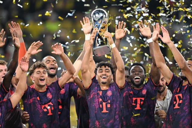 22 August 2026, Dortmund: Bayern Munich's Nathaniel Brown
celebrates with the trophy after winning the German Franz Beckenbauer Supercup soccer match against Borussia Dortmund at the Signal Iduna Park. Photo: Federico Gambarini/dpa - IMPORTANT NOTICE: Bundesliga and DFB regulations prohibit any use of photographs as image sequences and/or quasi-video.