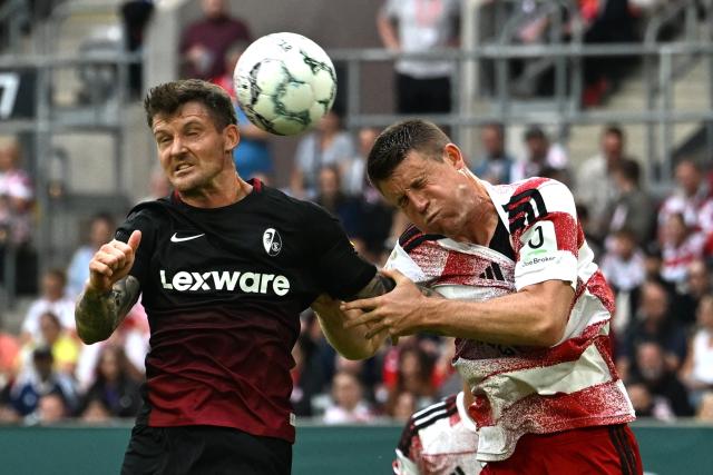 23 August 2026, North Rhine-Westphalia, Duesseldorf: Freiburg's Lukas Kuebler (L) and Fortuna Duesseldorf's Dominique Heintz battle for the ball during the German DFB Cup first round soccer match between Fortuna Duesseldorf and SC Freiburg at the Merkur Spiel-Arena. Photo: Federico Gambarini/dpa - WICHTIGER HINWEIS: Gemäß den Vorgaben der Bundesliga bzw. des DFB Deutscher Fußball-Bund ist es untersagt, in dem Stadion und/oder vom Spiel angefertigte Fotoaufnahmen in Form von Sequenzbildern und/oder videoähnlichen Fotostrecken zu verwerten bzw. verwerten zu lassen.