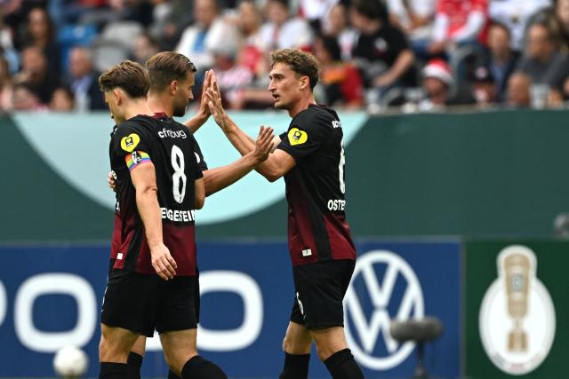 23 August 2026, North Rhine-Westphalia, Duesseldorf: Freiburg's Lucas Hoeler (C) celebrates scoring his side's first goal with teammates Patrick Osterhage (R) and Maximilian Eggestein during the German DFB Cup first round soccer match between Fortuna Duesseldorf and SC Freiburg at the Merkur Spiel-Arena. Photo: Federico Gambarini/dpa - WICHTIGER HINWEIS: Gemäß den Vorgaben der Bundesliga bzw. des DFB Deutscher Fußball-Bund ist es untersagt, in dem Stadion und/oder vom Spiel angefertigte Fotoaufnahmen in Form von Sequenzbildern und/oder videoähnlichen Fotostrecken zu verwerten bzw. verwerten zu lassen.
