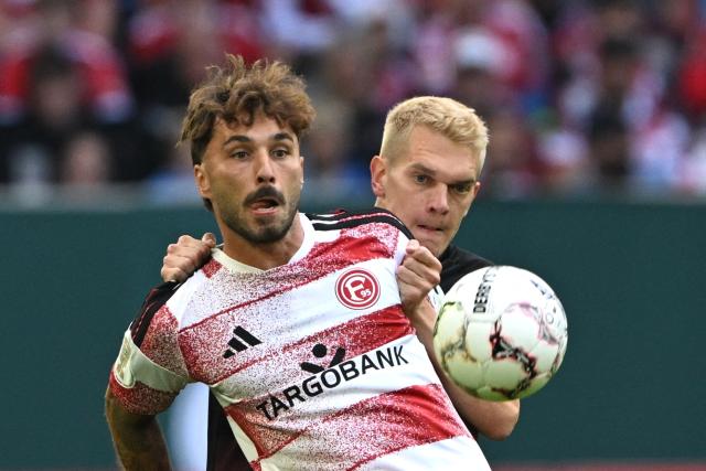 23 August 2026, North Rhine-Westphalia, Duesseldorf: Freiburg's Matthias Ginter (R) and Fortuna Duesseldorf's Fabian Schleusener battle for the ball during the German DFB Cup first round soccer match between Fortuna Duesseldorf and SC Freiburg at the Merkur Spiel-Arena. Photo: Federico Gambarini/dpa - WICHTIGER HINWEIS: Gemäß den Vorgaben der Bundesliga bzw. des DFB Deutscher Fußball-Bund ist es untersagt, in dem Stadion und/oder vom Spiel angefertigte Fotoaufnahmen in Form von Sequenzbildern und/oder videoähnlichen Fotostrecken zu verwerten bzw. verwerten zu lassen.