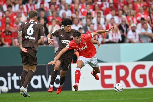 23 August 2026, North Rhine-Westphalia, Essen: Rot-Weiss Essen's Semir Telalovic (R) and St. Pauli's Tomoya Ando battle for the ball during the German DFB Cup first round soccer match between Rot-Weiss Essen and FC St. Pauli at the Stadion an der Hafenstrasse. Photo: Anke Waelischmiller/dpa - WICHTIGER HINWEIS: Gemäß den Vorgaben der Bundesliga bzw. des DFB Deutscher Fußball-Bund ist es untersagt, in dem Stadion und/oder vom Spiel angefertigte Fotoaufnahmen in Form von Sequenzbildern und/oder videoähnlichen Fotostrecken zu verwerten bzw. verwerten zu lassen.