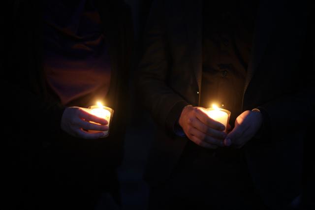 23 August 2026, North Rhine-Westphalia, Solingen: People hold candles in front of the city church during a memorial service for the victims of the Islamist terrorist attack two years ago, which left three people dead and many injured. Photo: Christoph Reichwein/dpa