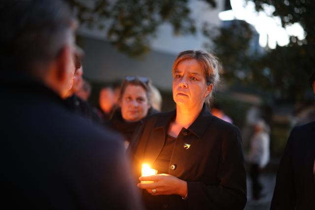 23 August 2026, North Rhine-Westphalia, Solingen: Deputy Minister-President of North Rhine-Westphalia Mona Neubaur  holds a candle during a memorial service in front of the Stadtkirche for the victims of the Islamist terrorist attack two years ago, which left three people dead and many injured. Photo: Christoph Reichwein/dpa