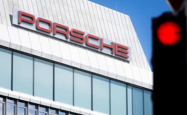 FILED - 27 July 2025, Baden-Wuerttemberg, Stuttgart: FILE PHOTO - A traffic light is glowing red in front of the Porsche logo on a building at the company's headquarters in Stuttgart-Zuffenhausen. Photo: Christoph Schmidt/dpa