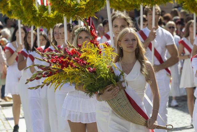 24 August 2026, Saxony, Kamenz: Students dressed in white carrying traditional flags on their shoulders or holding flower wreaths in their hands take part in the forestry festival parade. Photo: Daniel Wagner/dpa