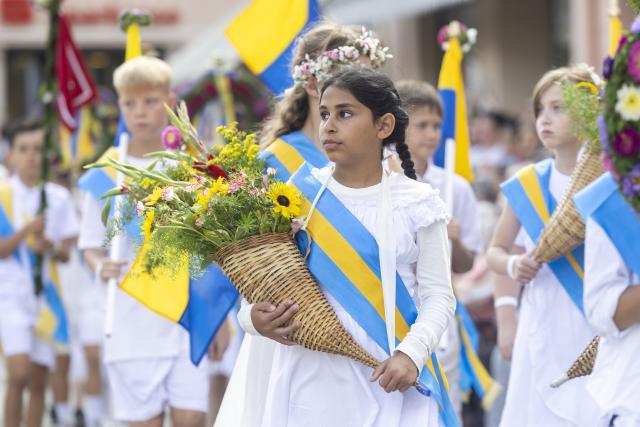 24 August 2026, Saxony, Kamenz: Students dressed in white carrying traditional flags on their shoulders or holding flower wreaths in their hands take part in the forestry festival parade. Photo: Daniel Wagner/dpa