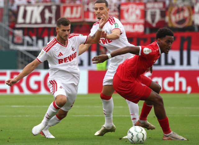 24 August 2026, Bavaria, Wuerzburg: Cologne's Tom Kraus (L) and Wuerzburg's David Kinsombi battle for the ball during the German DFB Cup first round soccer match between Wuerzburger Kickers and 1. FC Cologne at AKON Arena. Photo: Karl-Josef Hildenbrand/dpa - WICHTIGER HINWEIS: Gemäß den Vorgaben der Bundesliga bzw. des DFB Deutscher Fußball-Bund ist es untersagt, in dem Stadion und/oder vom Spiel angefertigte Fotoaufnahmen in Form von Sequenzbildern und/oder videoähnlichen Fotostrecken zu verwerten bzw. verwerten zu lassen.