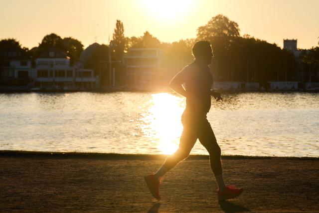 FILED - 14 August 2026, Hamburg: File Photo - A jogger is out for a run along the Alster at sunrise. Photo: Marcus Golejewski/dpa