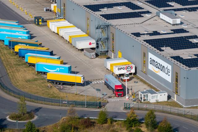 PRODUCTION - 25 August 2026, North Rhine-Westphalia, Rheinberg: Trucks are parked on the grounds of the Amazon logistics center in Rheinberg. Amazon is investing hundreds of millions of euros into the facility. Photo: Christoph Reichwein/dpa