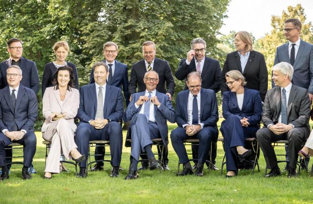 25 August 2026, Brandenburg, Neuhardenberg: German Chancellor Friedrich Merz (C) and members of the cabinet sit and stand together for a group photo during the federal government's closed-door meeting at Neuhardenberg Castle. The Federal Cabinet is meeting here for two days. Photo: Michael Kappeler/dpa
