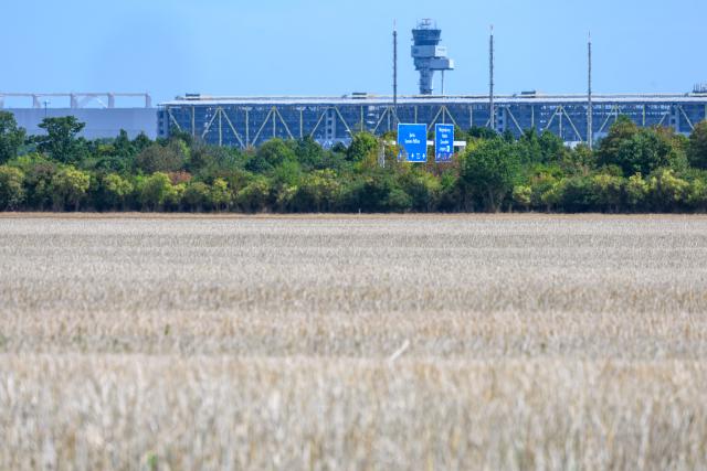 25 August 2026, Saxony-Anhalt, Kabelsketal: A view across a harvested field near Kabelsketal toward Leipzig/Halle Airport. German Chancellor Merz  has announced that the federal government plans to comment shortly on findings regarding the perpetrators of the incident involving an explosive-laden drone at Leipzig/Halle Airport on August 4. Photo: Hendrik Schmidt/dpa