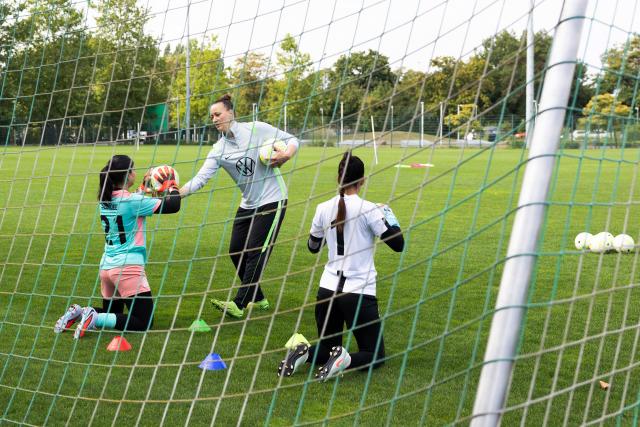 26 August 2026, Lower Saxony, Wolfsburg: Afghan goalkeeper Rukhsar Sediqee (L) completes a training session under the guidance of former German national team goalkeeper Almuth Schult (C) during the Media Day for the Afghan Women's National Team at VfL Wolfsburg. Photo: Irving Villegas/dpa