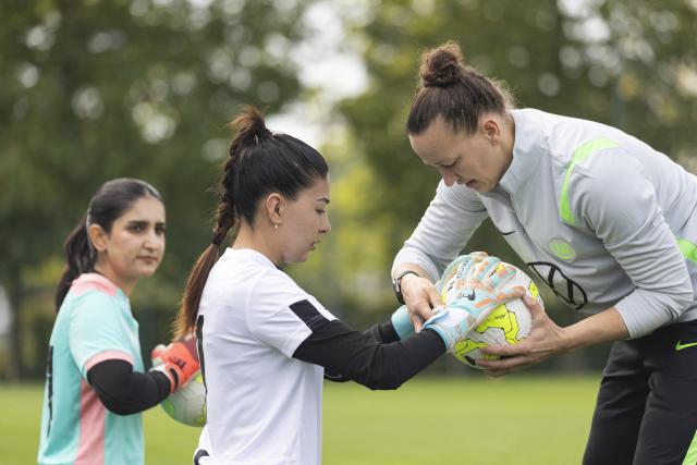 26 August 2026, Lower Saxony, Wolfsburg: Afghan goalkeeper Rukhsar Sediqee (C) completes a training session under the guidance of former German national team goalkeeper Almuth Schult (R) during the Media Day for the Afghan Women's National Team at VfL Wolfsburg. Photo: Irving Villegas/dpa