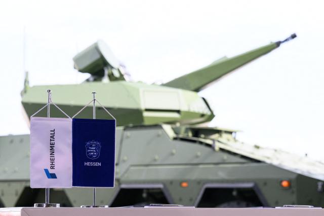 27 August 2026, Hesse, Calden: A Rheinmetall Skyranger anti-aircraft tank stands behind table flags representing Rheinmetall and the state of Hesse. According to the company, Rheinmetall is one of the largest manufacturers of combat vehicles, such as recovery vehicles and armored personnel carriers. Photo: Swen Pförtner/dpa