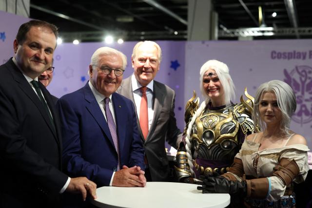 27 August 2026, North Rhine-Westphalia, Cologne: Nathanael Liminski (L-R), Minister for Federal and European Affairs, International Affairs, and Media of the State of North Rhine-Westphalia; Federal President Frank-Walter Steinmeier; and Gerald Böse, Chairman of the Executive Board of Koelnmesse, pose with cosplayers Paulina (Shadowheart from "Baldur's Gate") and Katharina (Ciri from "The Witcher") at the Cosplay Repair Station booth at Gamescom, the world's largest computer and video game trade show. Photo: Christoph Reichwein/dpa