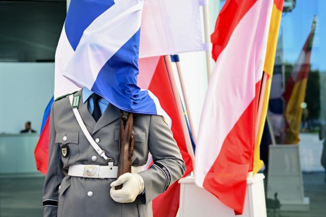 27 August 2026, Berlin: A guard at the Federal Chancellery is draped in a Finnish flag. Photo: Sebastian Gollnow/dpa