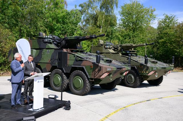 27 August 2026, Hesse, Kassel: Rheinmetall CEO Armin Papperger (L) and Hesse's Minister-President Boris Rhein stand in front of Boxer armored personnel carriers during a presentation at the Rheinmetall plant in Kassel. According to the company, Rheinmetall is one of the largest manufacturers of combat vehicles, such as recovery vehicles and armored personnel carriers. Photo: Swen Pförtner/dpa