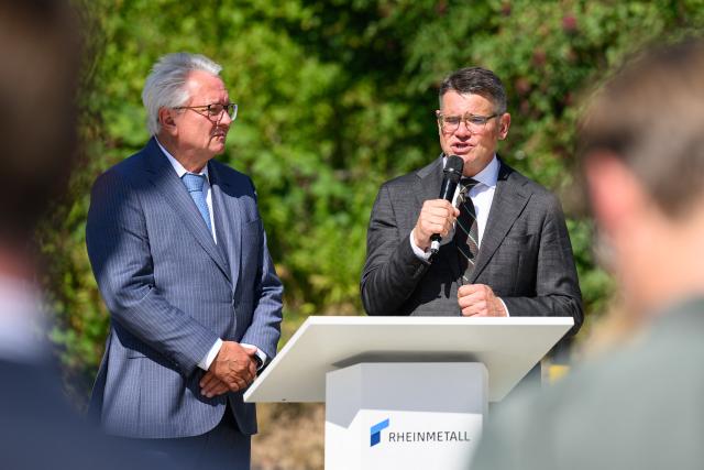 27 August 2026, Hesse, Kassel: Hesse's Minister President Boris Rhein (R) speaks alongside Rheinmetall CEO Armin Papperger during a plant visit in Kassel. According to the company, Rheinmetall is one of the largest manufacturers of combat vehicles, such as recovery vehicles and armored personnel carriers. Photo: Swen Pförtner/dpa