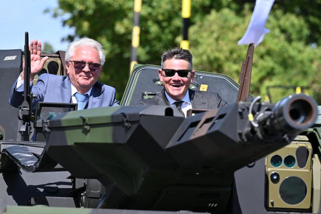 27 August 2026, Hesse, Kassel: Hesse's Minister President Boris Rhein (R) and Rheinmetall CEO Armin Papperger ride in a Boxer armored personnel carrier on the test track at the Rheinmetall plant in Kassel. According to the company, Rheinmetall is one of the largest manufacturers of combat vehicles, such as recovery vehicles and armored personnel carriers. Photo: Swen Pförtner/dpa