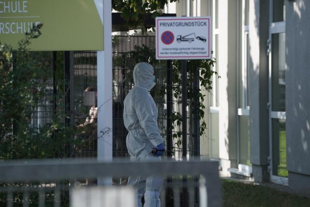 27 August 2026, Brandenburg, Gosen-Neu-Zittau: A forensic officer heads to the crime scene at a school in Gosen-Neu Zittau, where a woman and a man were killed in a violent incident. Photo: Manuel Genolet/dpa
