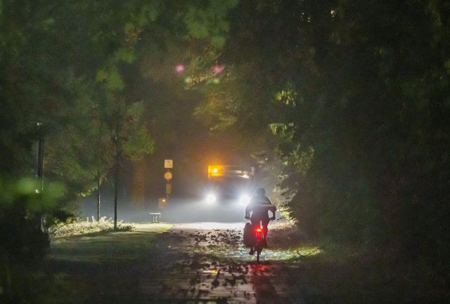 28 August 2026, Hesse, Frankfurt am Main: A commuter is walking along the bike and pedestrian path on the banks of the Main after a night of severe weather. Heavy rain and a thunderstorm swept through the city last night. Photo: Andreas Arnold/dpa