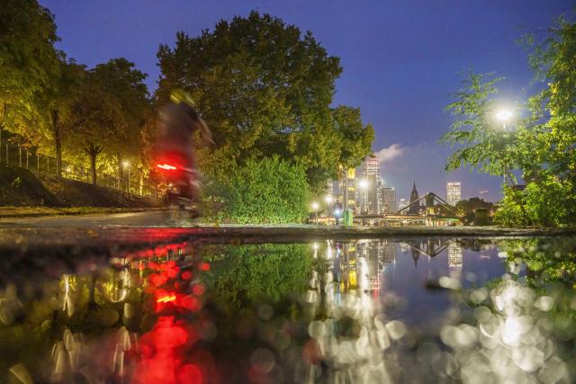 28 August 2026, Hesse, Frankfurt am Main: After a night of severe weather, puddles of rainwater have formed on the bike and walking path along the banks of the Main. Last night, heavy rain and a thunderstorm swept through the city. Photo: Andreas Arnold/dpa