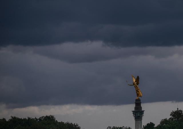 28 August 2026, Bavaria, Munich: The gilded Angel of Peace soars into the sky against the backdrop of a thunderstorm. Photo: Peter Kneffel/dpa