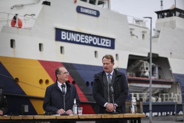 28 August 2026, Schleswig-Holstein, Flensburg: German Minister of the Interior Alexander Dobrindt (L) and Irish Minister for Justice, Home Affairs, and Migration Jim O'Callaghan deliver closing remarks in front of the patrol vessel "BP 82 Bamberg" during the Baltic Sea Security Summit at the Muerwik Naval Academy. Photo: Christian Charisius/dpa
