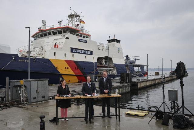 28 August 2026, Schleswig-Holstein, Flensburg: German Minister of the Interior Alexander Dobrindt (C), his press secretary Christina Lewinsky (L) and Irish Minister for Justice, Home Affairs, and Migration Jim O'Callaghan deliver closing remarks in front of the patrol vessel "BP 82 Bamberg" during the Baltic Sea Security Summit at the Muerwik Naval Academy. Photo: Christian Charisius/dpa