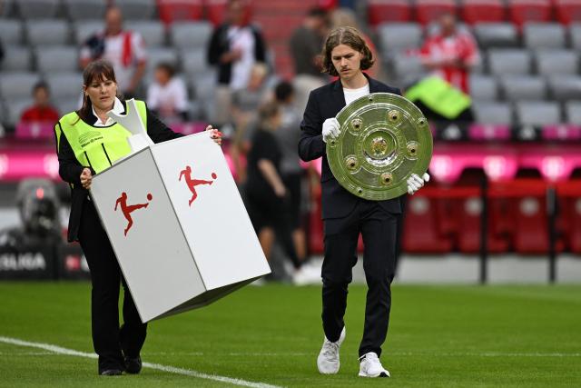 28 August 2026, Bavaria, Munich: The German Championship Trophy is carried into the stadium prior to the start of the German Bundesliga soccer match between FC Bayern Munich and VfB Stuttgart at Allianz Arena. Photo: Sven Hoppe/dpa - WICHTIGER HINWEIS: Gemäß den Vorgaben der Bundesliga bzw. des DFB Deutscher Fußball-Bund ist es untersagt, in dem Stadion und/oder vom Spiel angefertigte Fotoaufnahmen in Form von Sequenzbildern und/oder videoähnlichen Fotostrecken zu verwerten bzw. verwerten zu lassen.