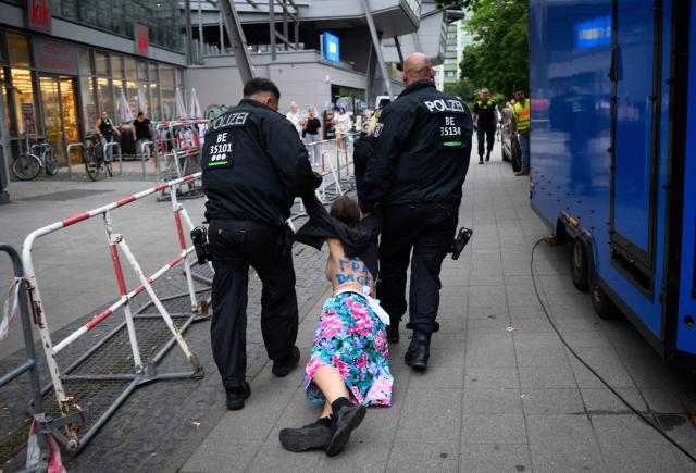 28 August 2026, Berlin: Police officers escort a Femen activist who was attempting to disrupt the appearance of Beatrix von Storch, the deputy chair of the AfD's Bundestag parliamentary group during an Alternative for Germany (AfD) campaign rally in Berlin-Lichtenberg. Photo: Bernd von Jutrczenka/dpa