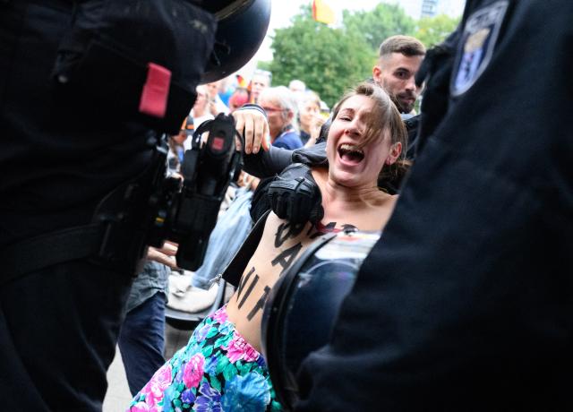 28 August 2026, Berlin: Police officers escort a Femen activist who was attempting to disrupt the appearance of Beatrix von Storch, the deputy chair of the AfD's Bundestag parliamentary group during an Alternative for Germany (AfD) campaign rally in Berlin-Lichtenberg. Photo: Bernd von Jutrczenka/dpa