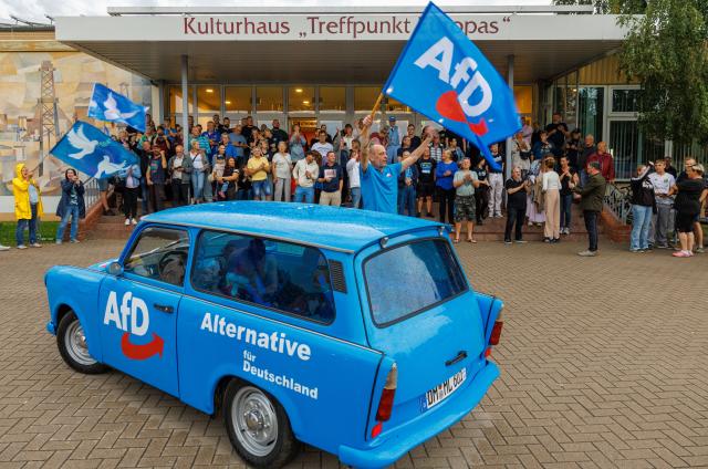 28 August 2026, Mecklenburg-Western Pomerania, Grimmen: Alternative for Germany (AfD) supporters celebrate in front of the "Treffpunkt Europas" cultural center ahead of the arrival of the two AfD national chairpersons for a campaign rally ahead of the state election in Mecklenburg-Western Pomerania. Photo: Jens Büttner/dpa