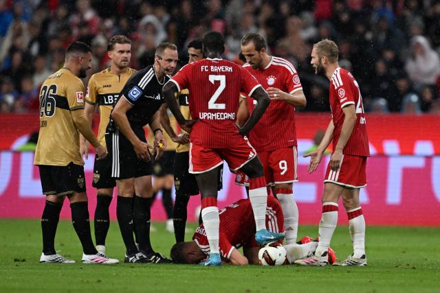 28 August 2026, Bavaria, Munich: Referee Soeren Storks stands next to Bayern Munich's Joshua Kimmich after a collision during the German Bundesliga soccer match between FC Bayern Munich and VfB Stuttgart at Allianz Arena. Photo: Sven Hoppe/dpa - WICHTIGER HINWEIS: Gemäß den Vorgaben der Bundesliga bzw. des DFB Deutscher Fußball-Bund ist es untersagt, in dem Stadion und/oder vom Spiel angefertigte Fotoaufnahmen in Form von Sequenzbildern und/oder videoähnlichen Fotostrecken zu verwerten bzw. verwerten zu lassen.