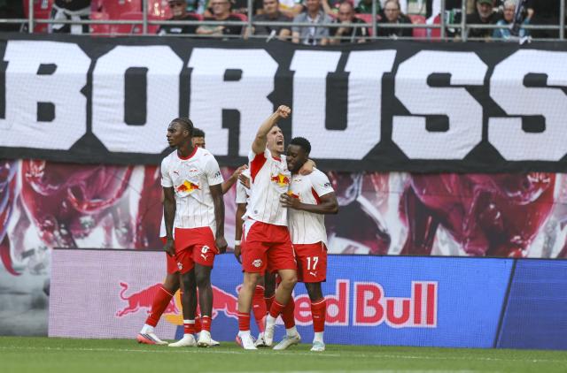 29 August 2026, Saxony, Leipzig: (R-L) Leipzig;s Ridle Baku (R) celebrates scoring his side's first goal with teammates Brajan Gruda and Ezechiel Banzuzi during the German Bundesliga soccer match between RB Leipzig and Borussia Moenchengladbach at Red Bull Arena. Photo: Jan Woitas/dpa - WICHTIGER HINWEIS: Gemäß den Vorgaben der Bundesliga bzw. des DFB Deutscher Fußball-Bund ist es untersagt, in dem Stadion und/oder vom Spiel angefertigte Fotoaufnahmen in Form von Sequenzbildern und/oder videoähnlichen Fotostrecken zu verwerten bzw. verwerten zu lassen.