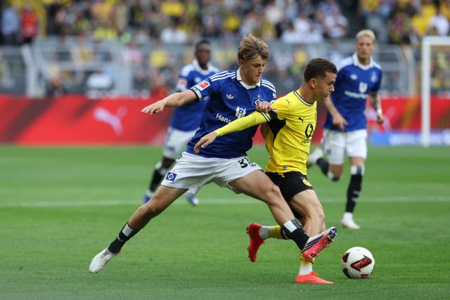 29 August 2026, North Rhine-Westphalia, Dortmund: Hamburger's Louis Lemke (L) and Borussia Dortmund's Konstantinos Karetsas battle for the ball during the German Bundesliga soccer match between Borussia Dortmund and Hamburger SV at Signal Iduna Park. Photo: Fabian Strauch/dpa - WICHTIGER HINWEIS: Gemäß den Vorgaben der Bundesliga bzw. des DFB Deutscher Fußball-Bund ist es untersagt, in dem Stadion und/oder vom Spiel angefertigte Fotoaufnahmen in Form von Sequenzbildern und/oder videoähnlichen Fotostrecken zu verwerten bzw. verwerten zu lassen.