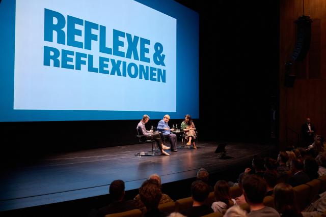 29 August 2026, Berlin: Former German Chancellor Angela Merkel (C) sits with Saba-Nur Cheema (R), political scientist, journalist, and advisor to the federal government on Islamophobia, and Meron Mendel, an Israeli-German educator, journalist, professor, and director of the Anne Frank Educational Center, at the Haus der Berliner Festspiele. The discussion is part of the "Reflexe & Reflexionen" theme days organized by the Berliner Festspiele. Photo: Annette Riedl/dpa