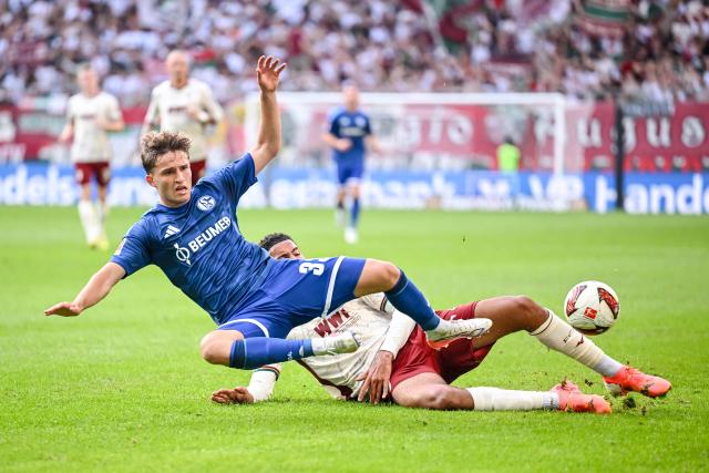 30 August 2026, Bavaria, Augsburg: Schalke's Vitalie Becker in action against Augsburg's Noahkai Banks during the German Bundesliga soccer match between FC Augsburg and FC Schalke 04 at the WWK-Arena. Photo: Harry Langer/dpa - IMPORTANT NOTICE: Bundesliga and DFB regulations prohibit any use of photographs as image sequences and/or quasi-video.