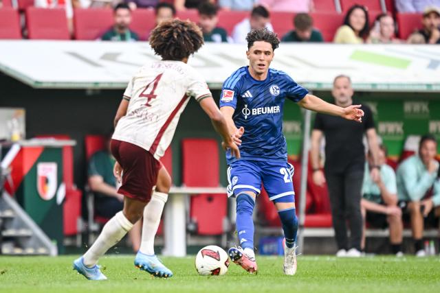 30 August 2026, Bavaria, Augsburg: Augsburg's Han-Noah Massengo in action against Schalke's Soufiane El-Faouzi during the German Bundesliga soccer match between FC Augsburg and FC Schalke 04 at the WWK-Arena. Photo: Harry Langer/dpa - IMPORTANT NOTICE: Bundesliga and DFB regulations prohibit any use of photographs as image sequences and/or quasi-video.