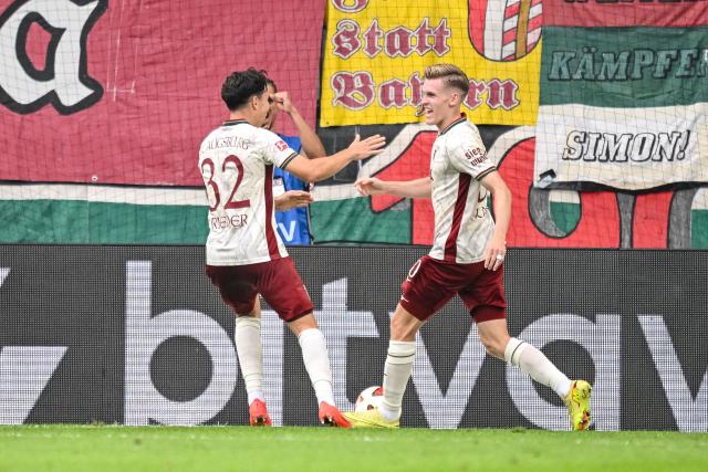 30 August 2026, Bavaria, Augsburg: Augsburg's Anton Kade celebrates scoring his side's second goal with teammate Fabian Rieder during the German Bundesliga soccer match between FC Augsburg and FC Schalke 04 at the WWK-Arena. Photo: Harry Langer/dpa - IMPORTANT NOTICE: Bundesliga and DFB regulations prohibit any use of photographs as image sequences and/or quasi-video.
