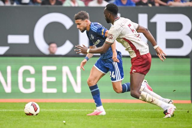 30 August 2026, Bavaria, Augsburg: Schalke's Adil Aouchiche and Augsburg's Chrislain Matsima battle for the ball during the German Bundesliga soccer match between FC Augsburg and FC Schalke 04 at the WWK-Arena. Photo: Harry Langer/dpa - IMPORTANT NOTICE: Bundesliga and DFB regulations prohibit any use of photographs as image sequences and/or quasi-video.